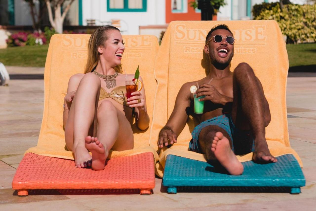 Sunrise Garden Beach Resort Hurghada Bagian luar foto A couple sunbathing